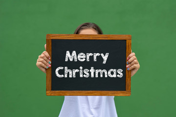 girl holding a blackboard with the message happy christmas written