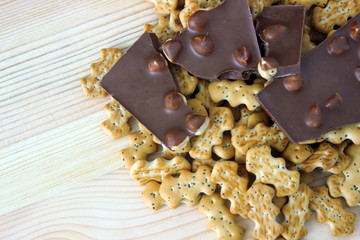 chocolate with nuts and biscuits with poppy on wooden background