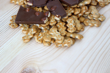 chocolate with nuts and biscuits with poppy on wooden background