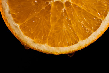 Slice of juicy orange on black background
