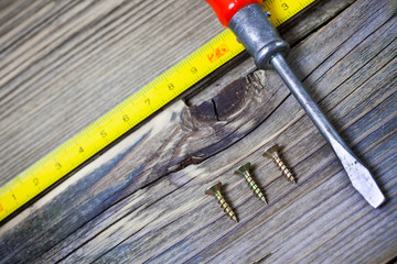 Fototapeta na wymiar antique screwdriver, screws and measuring lenght