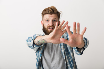 Worried bearded man dressed in plaid shirt