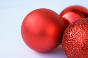 Primo piano tre bocce di natale rosse su sfondo bianco