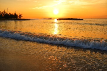 Obraz premium Sunset at the ocean makes the sea and the sky golden.