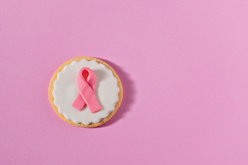 Cookies with pink ribbon as sign of the fight against breast cancer. Concept of International...