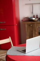 Work at kitchen near the laptop and red fridge