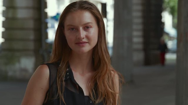Beautiful female model turns to look at the camera playfully, lifts her eyebrow slyly then smiles big