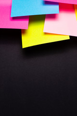 Many colorful sticky notes on black background