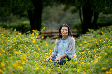 Beautiful woman in a flower field smiling and Happy