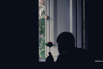 Sad man and rose in valentines day.Low key style.