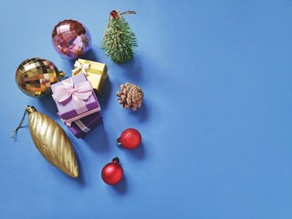 Flat lay Christmas composition. Golden, red baubles, gift boxes, decorative spruce tree and pine...