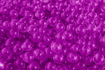 Water purple gel balls with bokeh. Polymer gel. Silica gel. Balls of purple hydrogel. Crystal liquid ball with reflection. Purple balls texture background. Macro