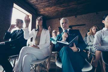 Obraz premium Low below angle view of elegant classy stylish business people crowd sitting on chairs attending financial course management development asking questions at loft interior work place station