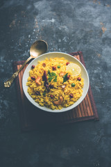 Lemon Rice is a South Indian turmeric rice or maharashtrian recipe called fodnicha bhat using leftover rice garnished with nuts curry leaves and lemon juice, selective focus