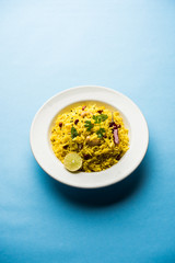 Lemon Rice is a South Indian turmeric rice or maharashtrian recipe called fodnicha bhat using leftover rice garnished with nuts curry leaves and lemon juice, selective focus