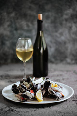 Mussels boiled in a sauce of white wine, served with toast and lemon. Gourmet italian cuisine.