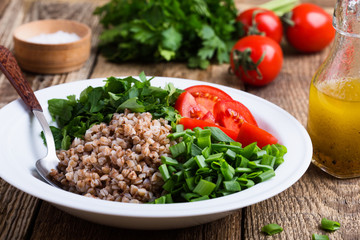 Healthy cooked buckwheat grain salad with fresh vegetables