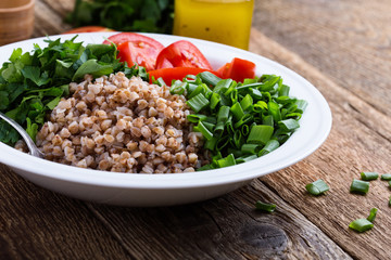 Healthy cooked buckwheat grain salad with fresh vegetables