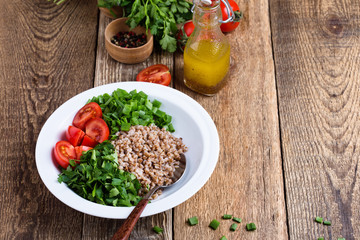 Healthy cooked buckwheat grain salad with fresh vegetables