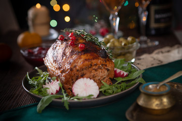 Grilled pork loin on the Christmas table with Christmas lights in the background