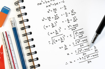 Handwriting of mathematics quadratic equation formula on examination, practice, quiz or test in maths class. Solving exponential equations background concept.