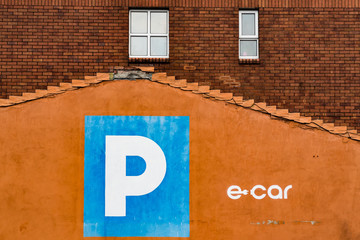 Obraz premium Parking and electric car charging sign on building wall