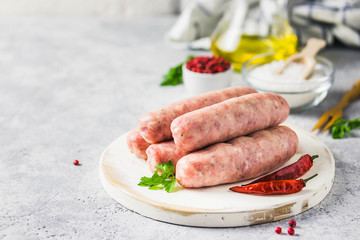 Raw sausages with spices, herbs. Selective focus, space for text.