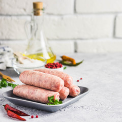Raw sausages with spices, herbs. Selective focus, space for text.