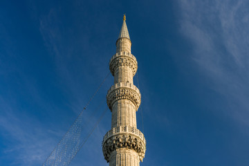 Detail of one of a minaret of the Blue mosque in late afternoon light against a blue sky, Istanbul,...