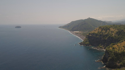 beach with black volcanic sand, mountains in tropical resort. aerial seascape sand beach with turquoise water. Seascape, ocean and beautiful beach.Travel concept. Indonesia, Bali