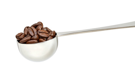 Whole coffee beans in metallic measuring scoop isolated on white background