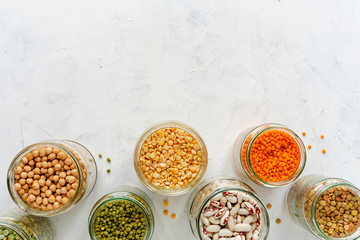 Open glass jars full of assorted dried legumes