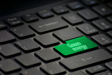computer keyboard with a green key with the text "green energy"
