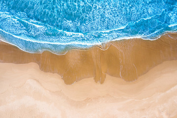 Fototapeta na wymiar Vista aerea di una spiaggia con mare azzurro e onde