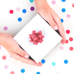 Obraz na płótnie Canvas Hands holding a gift box over confetti