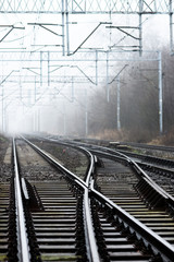 Crossroads of railway tracks in the fog.