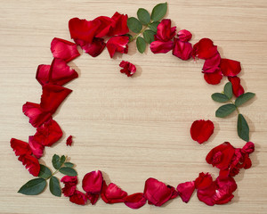 frame red roses petals on wooden