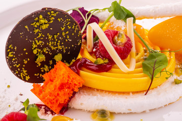 Mousse from passion fruit with raspberry sorbet and chocolate in coconut flakes