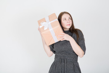 Portrait of a happy young woman in sunglasses isolated, holding present box