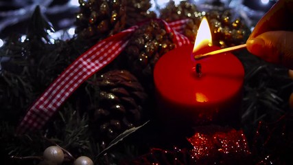 Woman Lighting A Red Christmas Candle