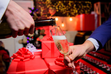 Celebrate new year with champagne. Cheers concept. Hands pouring champagne into elegant glass christmas decorations background. Last minute before new year. Drink champagne or sparkling wine