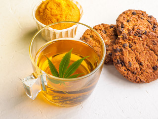 Breakfast with sweet cookies. tea with marijuana. Cannabis leaf is brewed in herbal decoction to treat pain and increase appetite. concept of marijuana use for medicinal purposes.