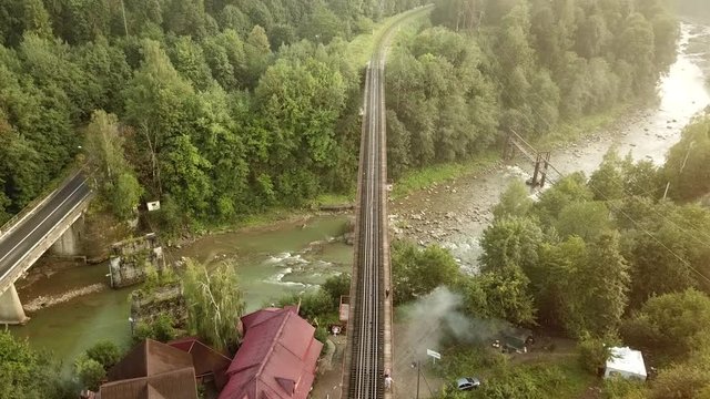 Aerial footage of people walking on a railway bridge over the Prut River in Yaremche, the city on the Carpathian Mountains in Ukraine.