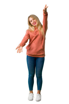 A full-length shot of a Young girl presenting and inviting to come with hand on isolated white background