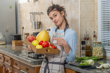 smiling young woman with fruits in the kitchen