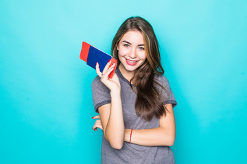 Portrait of a happy smiling young girl holding passport and travelling tickets isolated over blue background