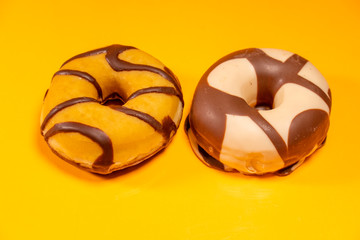 Various decorated doughnuts on a orange background isolateds. Sweet and colourful doughnuts