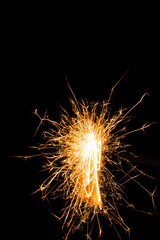 Bright burning Christmas sparkler on black background