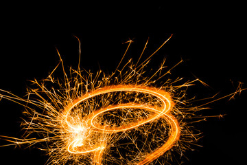 Close-up view of festive burning new year sparkler on black background