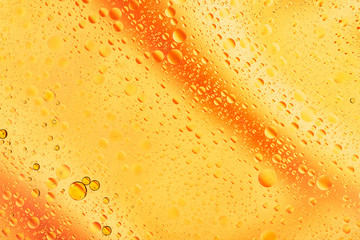 water drops on glass with orange and pink background, close-up 